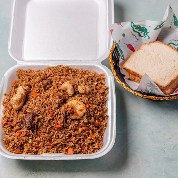 Fried rice with chicken, shrimp, and vegetables in a takeout container, with bread slices in a basket.